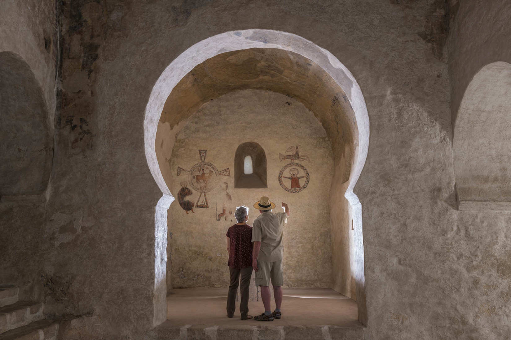Una parella visitant una església romànica / Una pareja visitando una iglésia románica